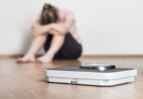 woman with eating disorder and a scale